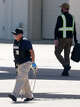 A law enforcement officer carries metal restraints near an Eastern Air Express plane at Dallas Love Field on Tuesday, July 28, 2026, in Dallas.