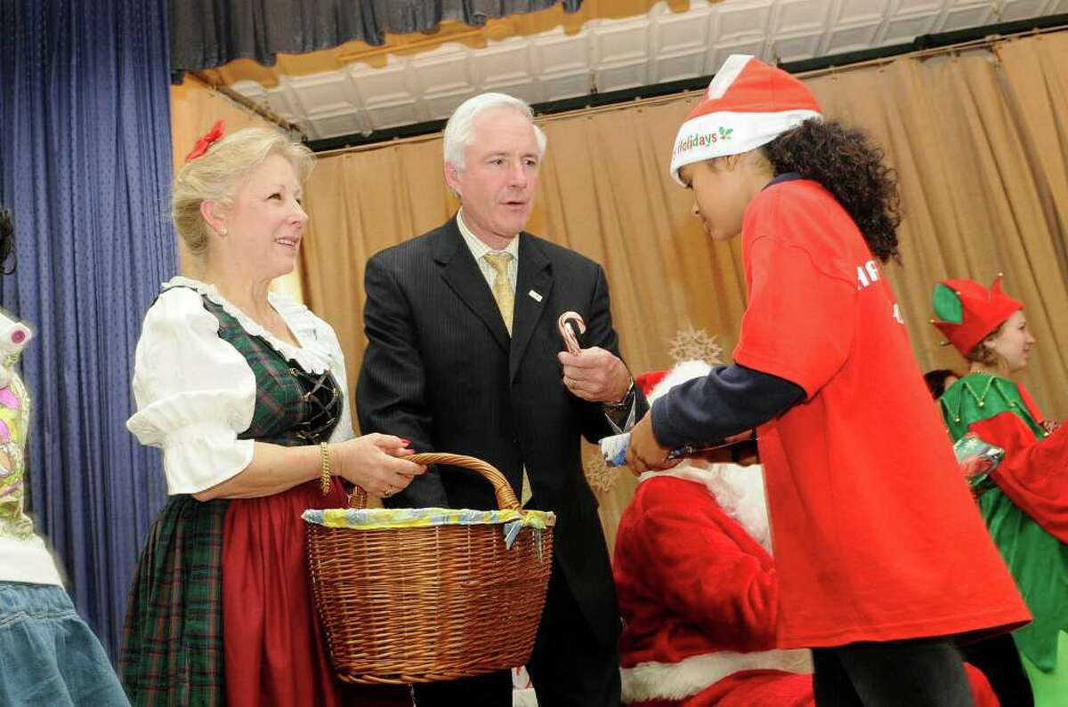 Mayor Bill Finch and Gold Star Mother Kathryn Cross hand a candy cane to Victoria Diaz as the Hall School celebrates the holiday season while remembering our country's fallen heroes in Bridgeport, CT on Wednesday, December 22, 2010. The event is sponsored by the Connecticut Fallen Heroes Foundation and the Sikorsky Finance Women's Forum.