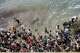 People walk on a beach as they attempt to cross from the Moroccan northern town of Fnideq to the Spanish enclave of Ceuta, Friday, July 31, 2026.