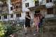 Residents leave their damaged home after a Russian air guided bomb strike in Zaporizhzhia, Ukraine, Monday, Aug. 10, 2026.