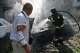 Rescue workers try to put out a fire of a residential building and cars burning after a Russian air guided bomb strike in Zaporizhzhia, Ukraine, Monday, Aug. 10, 2026.