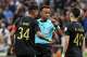 FILE - Referee Omar Artan, center, of Somalia, is confronted by players after calling a penalty kick during the CAF Champions League final soccer match between AS FAR Rabat and Mamelodi Sundowns, in Rabat, Morocco, Sunday, May 24, 2026.