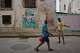 Men argue in front of a weathered mural of Fidel Castro in Havana, Cuba, Wednesday, Aug. 12, 2026.