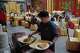 A waiter prepares to serve dishes for customers at Fangshan Restaurant in Beijing on July 23, 2026.