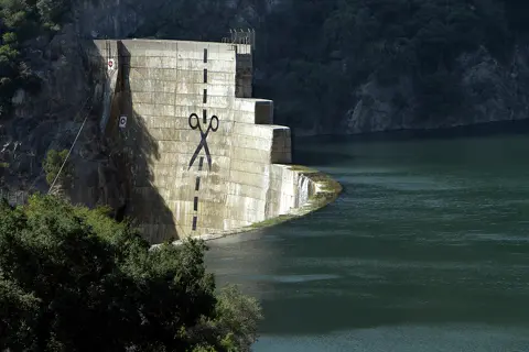 A giant pair of scissors along with 8-foot-tall dotted lines guiding where the massive shears should go was painted on the face of the 200-foot Matilija Dam in Ojai, Calif., in 2011. The dotted line runs from the top of the defunct concrete dam down to the waterline.