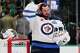 FILE - Winnipeg Jets goaltender Connor Hellebuyck stands by the net during a time out from play against the Dallas Stars in the first period of an NHL hockey game, April 2, 2026, in Dallas.
