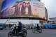 FILE - Motorbikes drive past a billboard depicting Iran's late Supreme Leader Ayatollah Ali Khamenei, center, handing the country's flag to his son and successor, Ayatollah Mojtaba Khamenei, right, as the late revolutionary founder Ayatollah Ruhollah Khomeini stands at left, in a square in downtown Tehran, Iran, March 10, 2026.