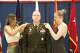 Colonel rank insignias are placed on Josh Heimroth’s uniform by his wife, Amanda, and daughter, Shayna during a ceremony in Latham.