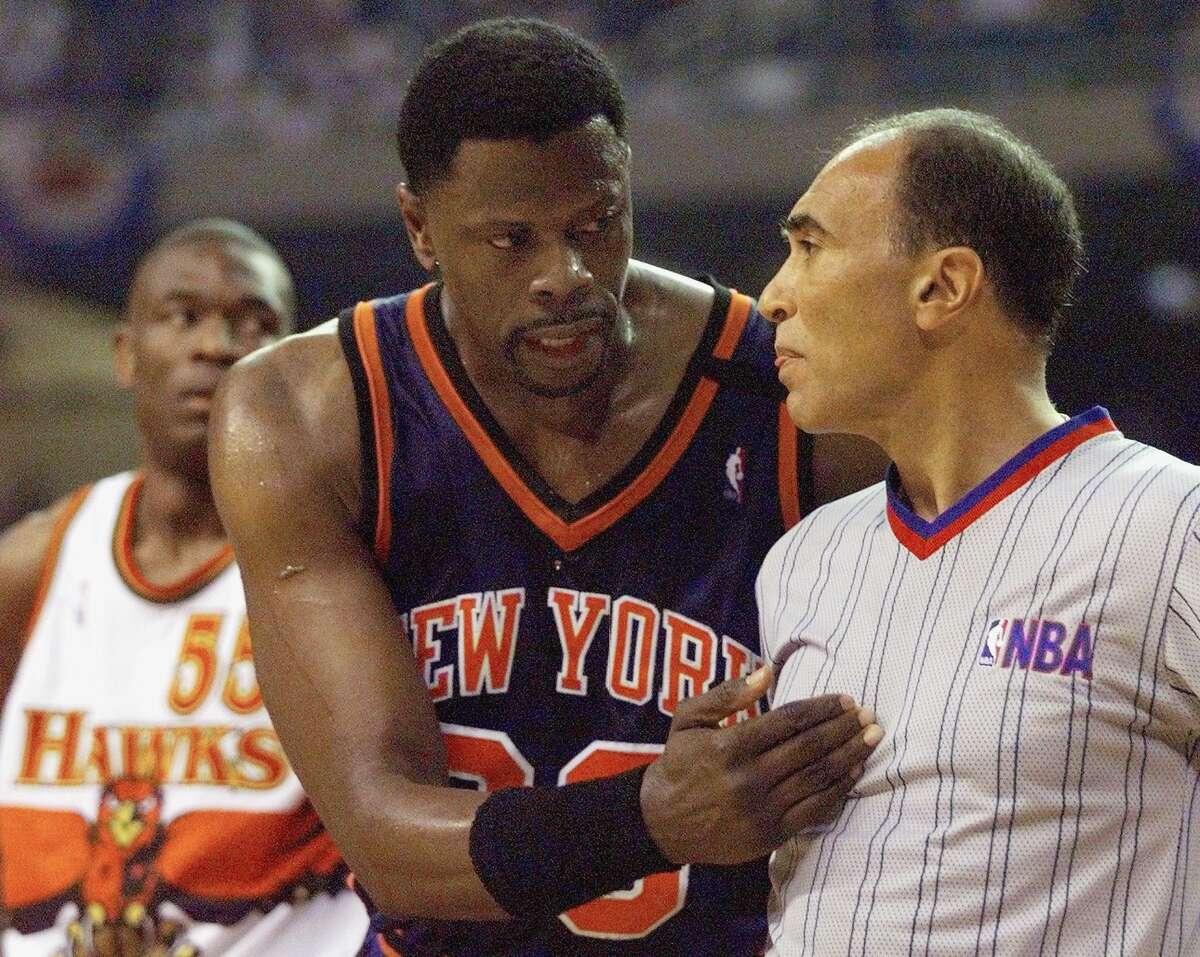 Patrick Ewing of the New York Knicks argues with NBA official Ronnie Nunn as Dikenbe Mutombo of the Atlanta Hawks looks on 20 May, 1999, during the first half of the second game of the NBA Eastern Conference semifinals game at the Georgia Dome in Atlanta, Georgia. Nunn will be inducted in the Danbury Old Timers Hall of Fame in September.