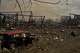 Destroyed vehicles and debris are scattered the day after a Russian attack struck a warehouse, followed by an explosion, in the village of Myla, outskirts of Kyiv, Sunday, Aug. 30, 2026.