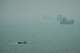 A motorboat travels past commercial vessels anchored amid haze in the Strait of Hormuz off Bandar Abbas, Iran, Monday, Sept. 7, 2026.