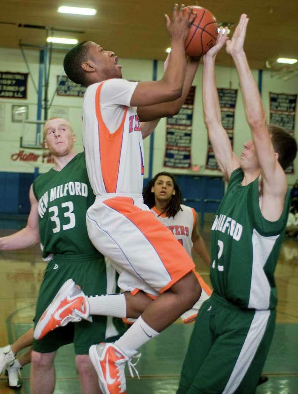 Danbury Hatters Malik Sanders tries to find the handle on the ball as he pushes against New Milford's Steven Cronin during a varsity game at Danbury High School. Thursday, Dec. 23, 2010