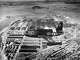 A jet plane from the Naval Air Reserve flies directly above the huge Oakland Naval Supply Center in 1950.