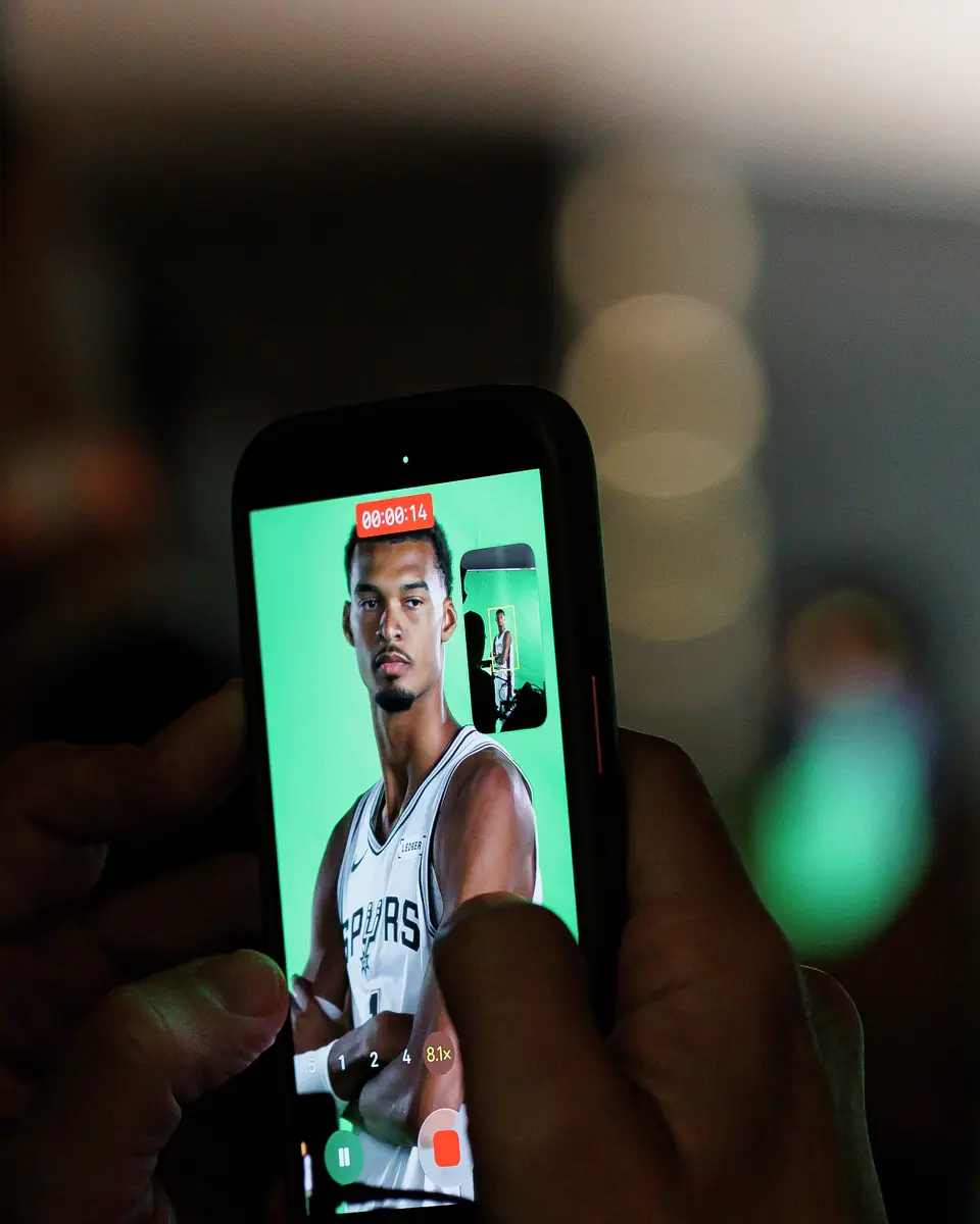 A reporter films San Antonio Spurs center Victor Wembanyama as he poses for photos and video clips during the NBA basketball team’s media day at the Victory Capital Performance Center in San Antonio, Monday, Sept. 28, 2026.