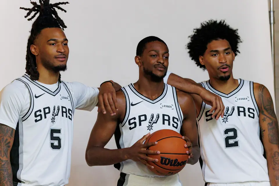 San Antonio Spurs guards Stephon Castle (5), De’Aaron Fox (4) and Dylan Harper (2) pose for official portraits together during the NBA basketball team’s media day at the Victory Capital Performance Center in San Antonio, Monday, Sept. 28, 2026.