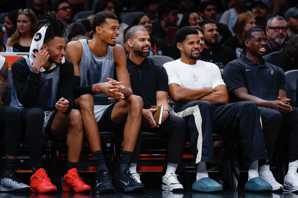 Spurs’ Stephon Castle, from left, Victor Wembanyama and Tobias Harris, second from right, and members of the Spurs’ coaching staff watch their teammates compete against each other during the Silver & Black Scrimmage at Frost Bank Center in San Antonio, Sunday, Oct. 4, 2026.