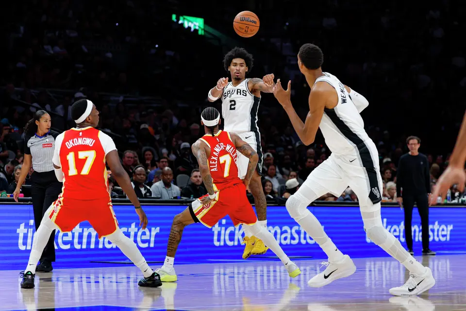 San Antonio Spurs guard Dylan Harper (2) makes a pass to center Victor Wembanyama (1) as he drives to the basket during the second quarter of the preseason opener at Frost Bank Center in San Antonio, Thursday, Oct. 8, 2026.