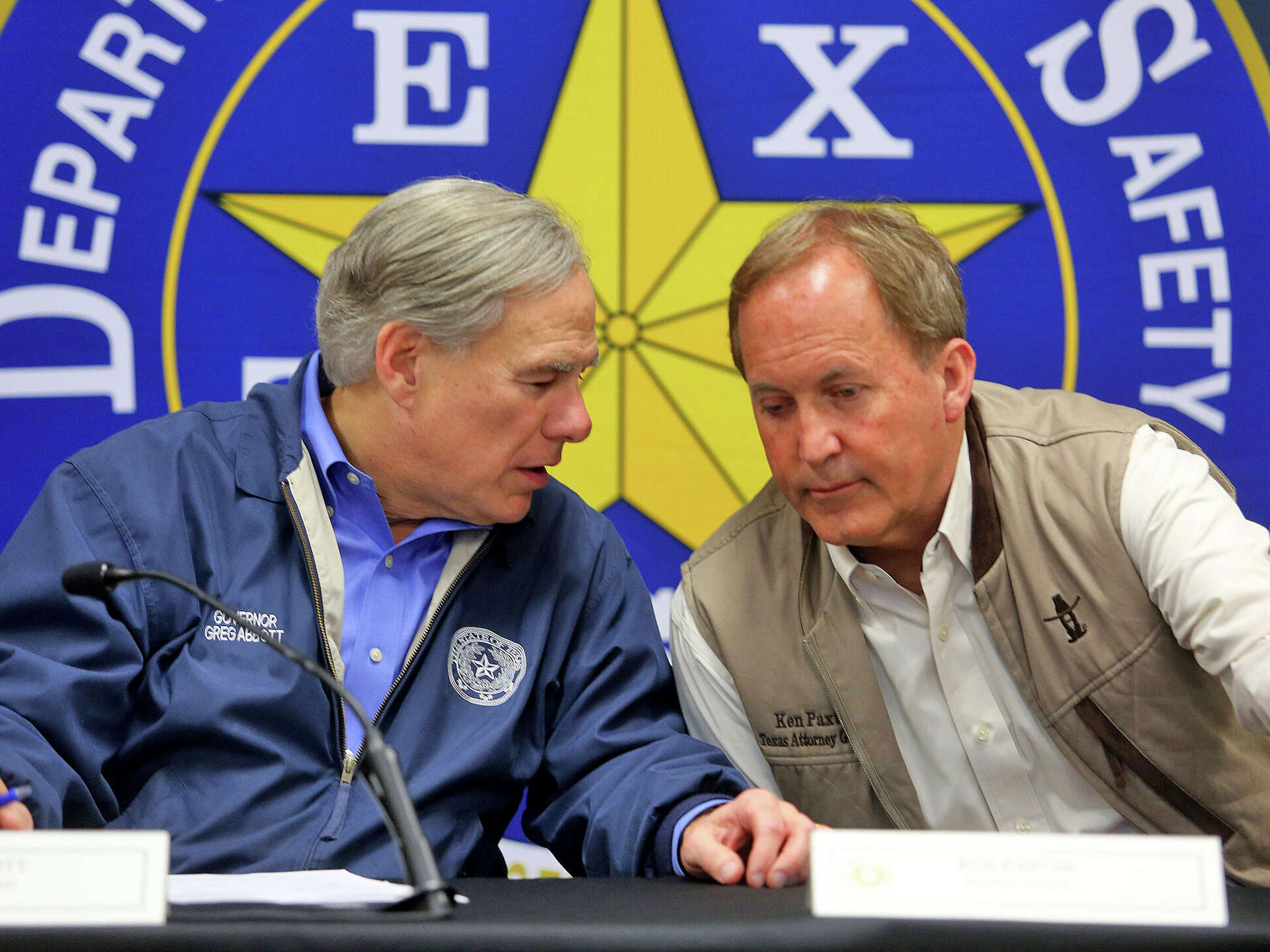 Texas Gov. Greg Abbott, left, and Texas Attorney General Ken Paxton confer during a conference after an Operation Lone Star roundtable discussion at the Texas D