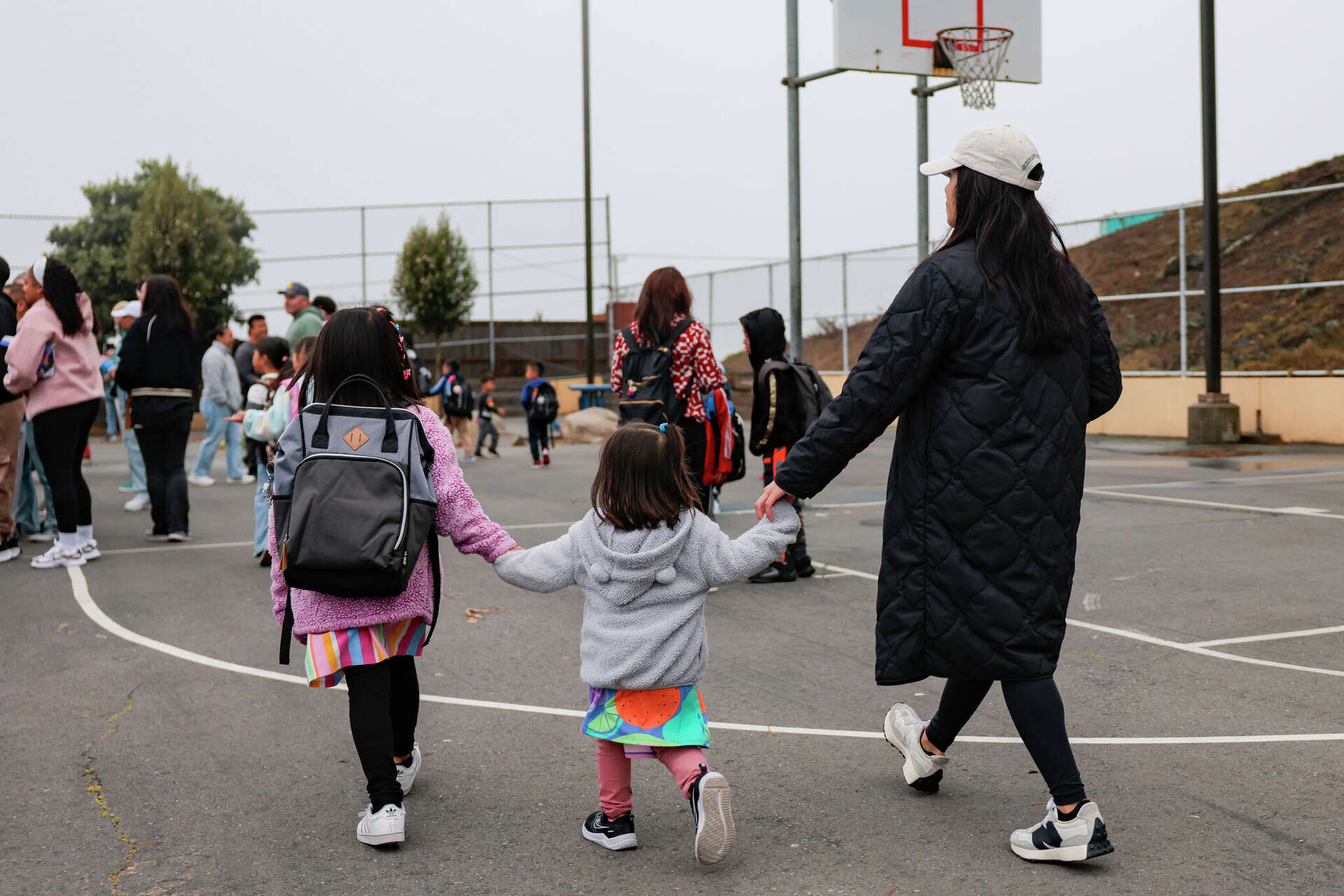 Parents walk their students in on the first day of school at Jose Ortega Elementary in San Francisco in August. The school board on Tuesday night voted to assig