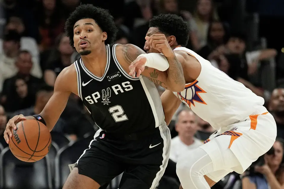 San Antonio Spurs guard Dylan Harper (2) gets fouled by Phoenix Suns forward Ryan Dunn during a preseason NBA basketball game, Saturday, Oct. 10, 2026, in Phoenix. (AP Photo/Ross D. Franklin)