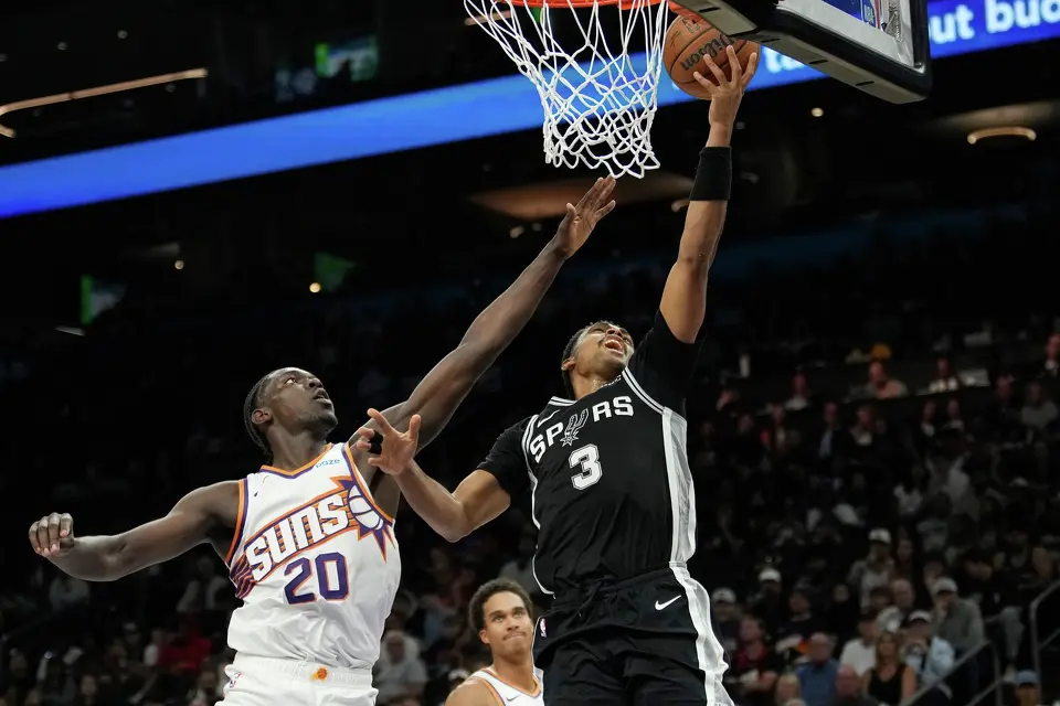 San Antonio Spurs forward Keldon Johnson (3) drives to the basket against Phoenix Suns forward Rasheer Fleming (20) during a preseason NBA basketball game, Saturday, Oct. 10, 2026, in Phoenix. (AP Photo/Ross D. Franklin)