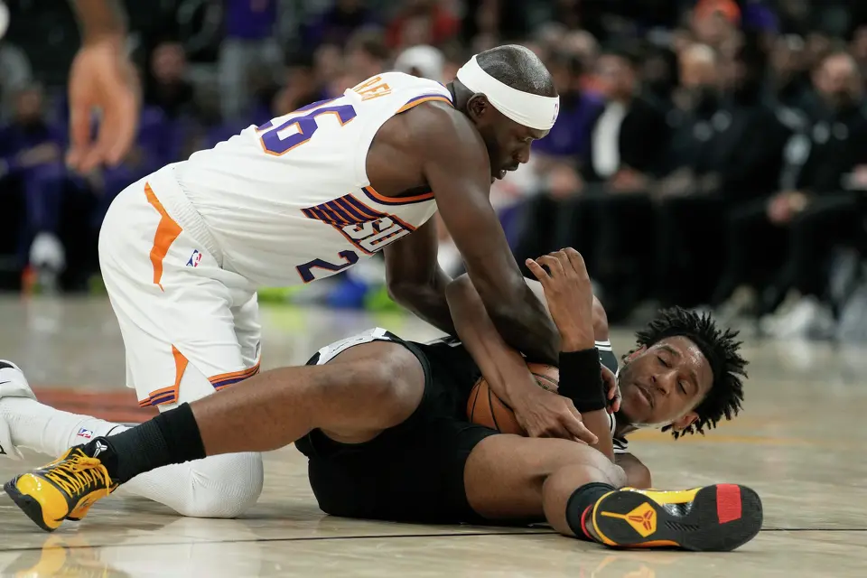 Phoenix Suns center Duop Reath, left, forces a jump ball with San Antonio Spurs center Tarris Reed Jr. during a preseason NBA basketball game, Saturday, Oct. 10, 2026, in Phoenix. (AP Photo/Ross D. Franklin)