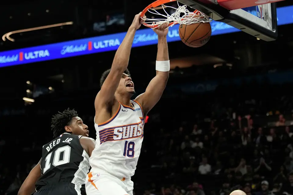 Phoenix Suns forward Koa Peat (18) dunks against San Antonio Spurs center Tarris Reed Jr. (10) during a preseason NBA basketball game, Saturday, Oct. 10, 2026, in Phoenix. (AP Photo/Ross D. Franklin)