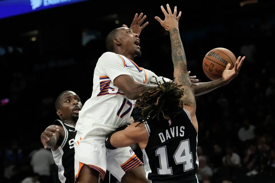 Phoenix Suns guard Jamaree Bouyea (17) goes up for a shot against San Antonio Spurs guard RJ Davis (14) and Spurs forward David Jones Garcia, left, during a preseason NBA basketball game, Saturday, Oct. 10, 2026, in Phoenix. (AP Photo/Ross D. Franklin)