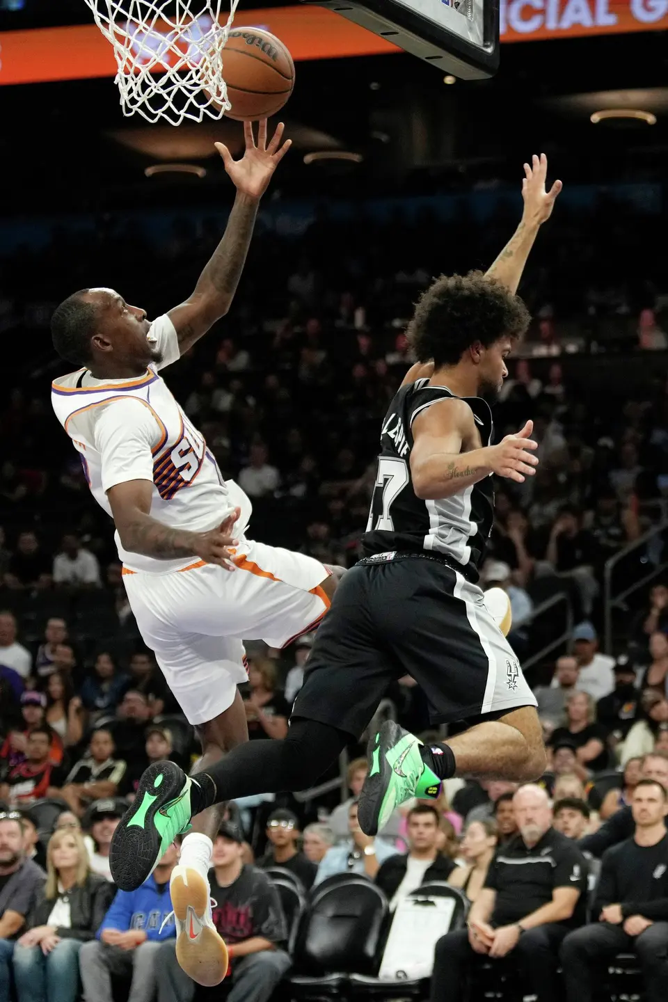 Phoenix Suns guard Jamaree Bouyea, left, is fouled by San Antonio Spurs guard Ja'kobi Gillespie, right, during a preseason NBA basketball game, Saturday, Oct. 10, 2026, in Phoenix. (AP Photo/Ross D. Franklin)