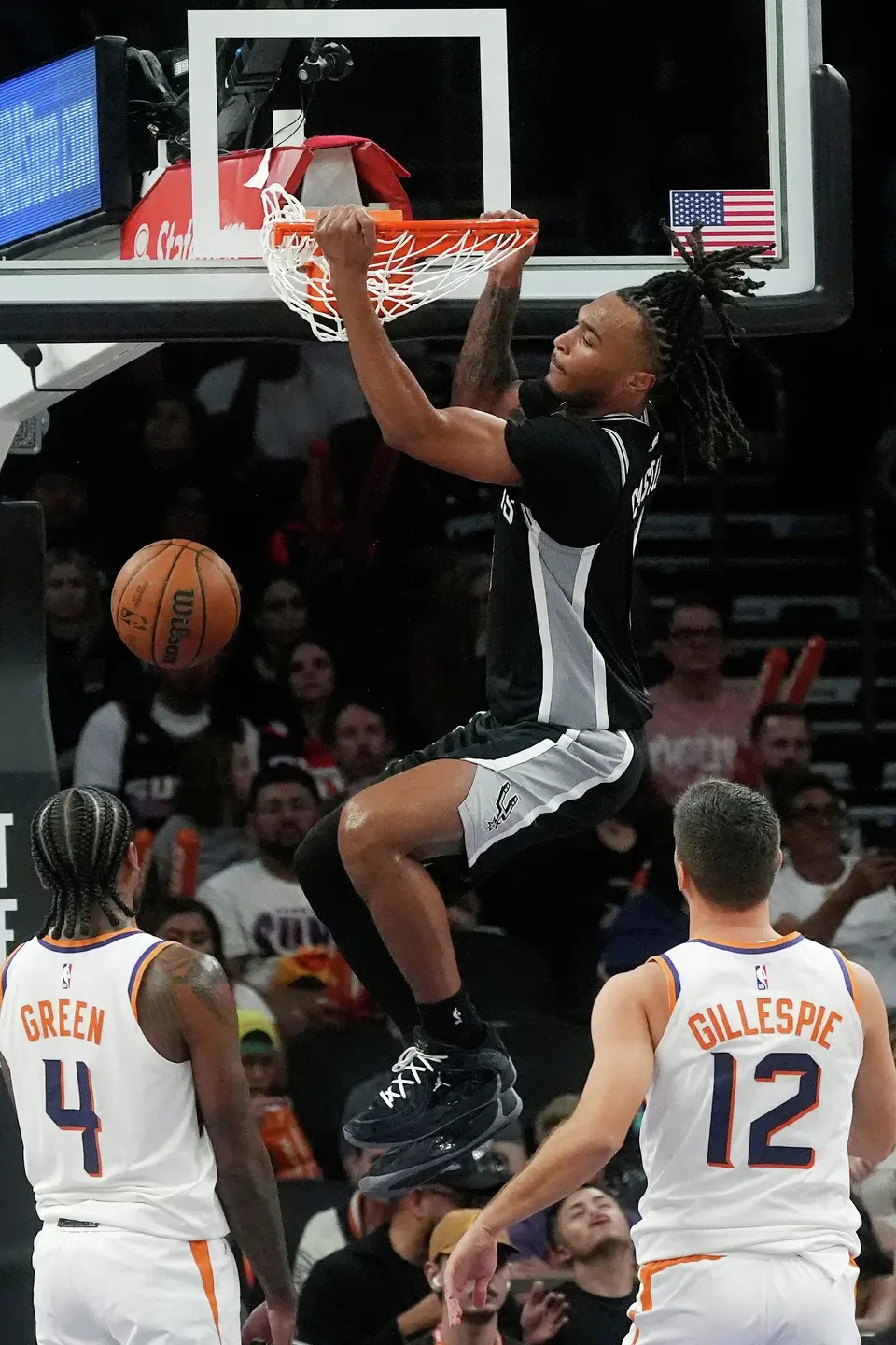 San Antonio Spurs guard Stephon Castle, center, dunks as Phoenix Suns guards Jalen Green (4) and Collin Gillespie (12) look on during a preseason NBA basketball game, Saturday, Oct. 10, 2026, in Phoenix. (AP Photo/Ross D. Franklin)