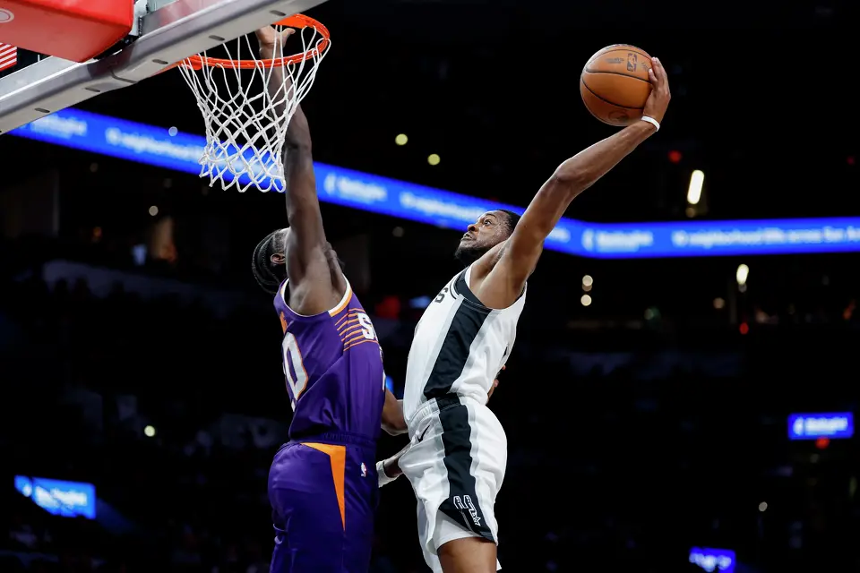 San Antonio Spurs guard De'aaron Fox (4) dunks over Phoenix Suns forward Rasheer Fleming (20) during the second quarter of a preseason NBA game at Frost Bank Center in San Antonio, Wednesday, Oct. 14, 2026.