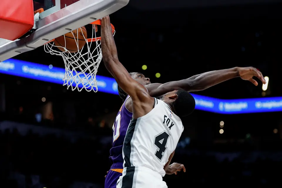 San Antonio Spurs guard De'aaron Fox (4) dunks over Phoenix Suns forward Rasheer Fleming (20) during the second quarter of a preseason NBA game at Frost Bank Center in San Antonio, Wednesday, Oct. 14, 2026.