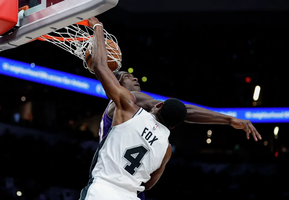 San Antonio Spurs guard De'aaron Fox (4) dunks over Phoenix Suns forward Rasheer Fleming (20) during the second quarter of a preseason NBA game at Frost Bank Center in San Antonio, Wednesday, Oct. 14, 2026.