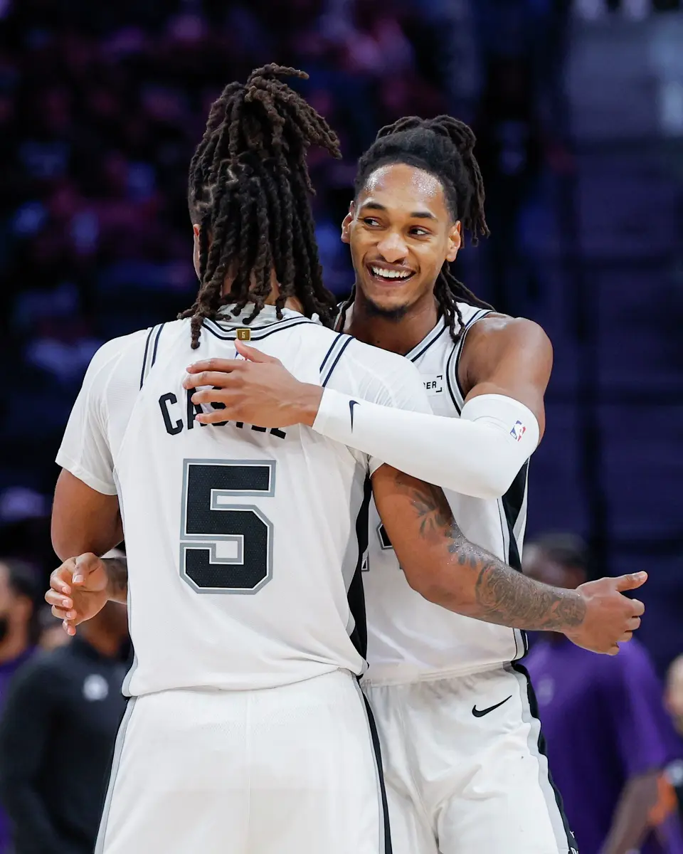 San Antonio Spurs guard Stephon Castle (5) hugs teammate Devin Vassell (24) after Vassell dunked against the Phoenix Suns during the second half of a preseason NBA basketball game Wednesday, Oct. 14, 2026, in San Antonio. The Spurs won 123-103.