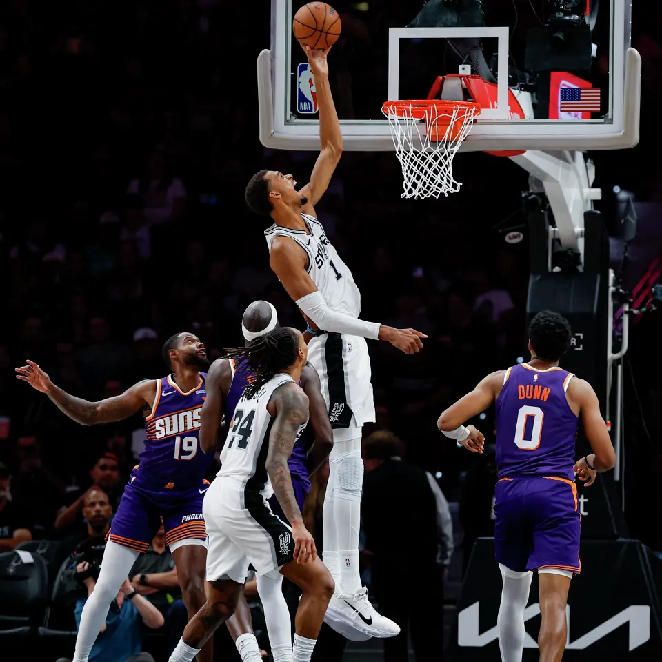 San Antonio Spurs center Victor Wembanyama (1) tips in a high pass from teammate Devin Vassell (24) during the second half of a preseason NBA basketball game against the Phoenix Suns on Wednesday, Oct. 14, 2026, in San Antonio. The Spurs won 123-103.