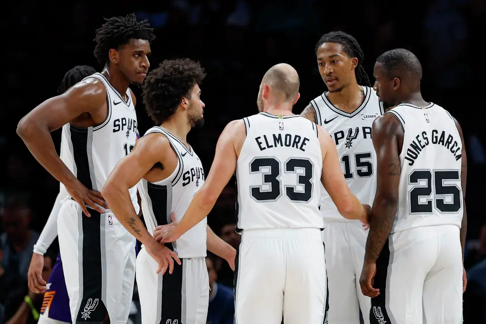 San Antonio Spurs center Tarris Reed Jr. (10), guards Ja'kobi Gillespie (17) and Jon Elmore (33), forwards Maliq Brown (15) and David Jones Garcia (25) huddle during the second half of a preseason NBA game against the Phoenix Suns at Frost Bank Center in San Antonio, Wednesday, Oct. 14, 2026. The Spurs defeated the Suns 123-103.