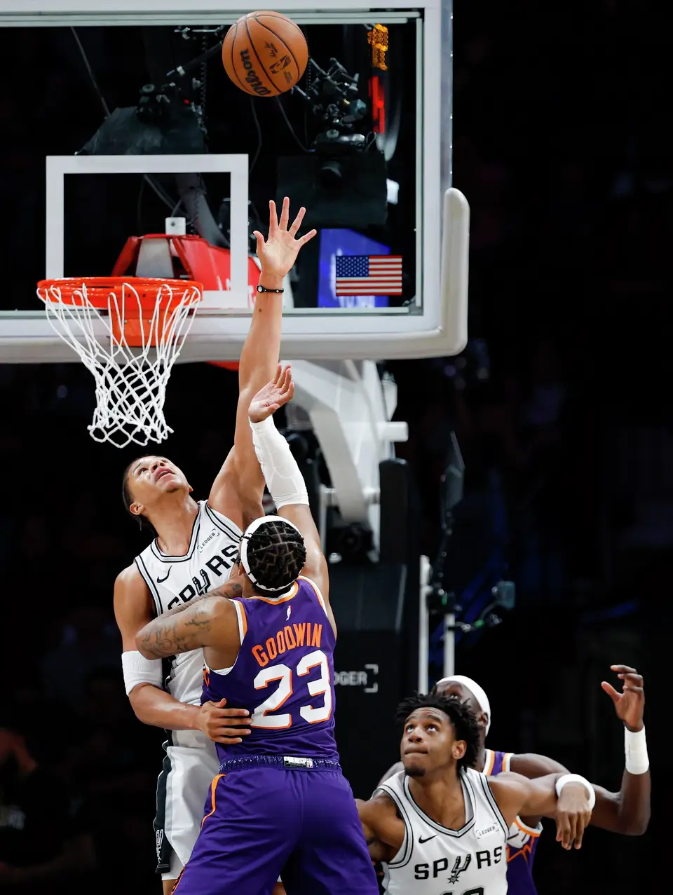 San Antonio Spurs forward Carter Bryant (11) attempts to block a shot by Phoenix Suns guard Jordan Goodwin (23) during the first half of a preseason NBA basketball game Wednesday, Oct. 14, 2026, in San Antonio.