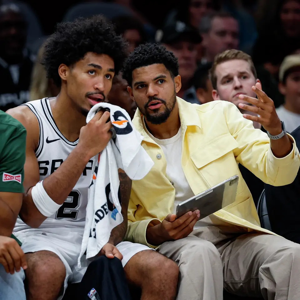 San Antonio Spurs guard Dylan Harper and forward Tobias Harris talk as they watch their teammates take on the Phoenix Suns in the first half of a preseason NBA game at Frost Bank Center in San Antonio, Wednesday, Oct. 14, 2026.
