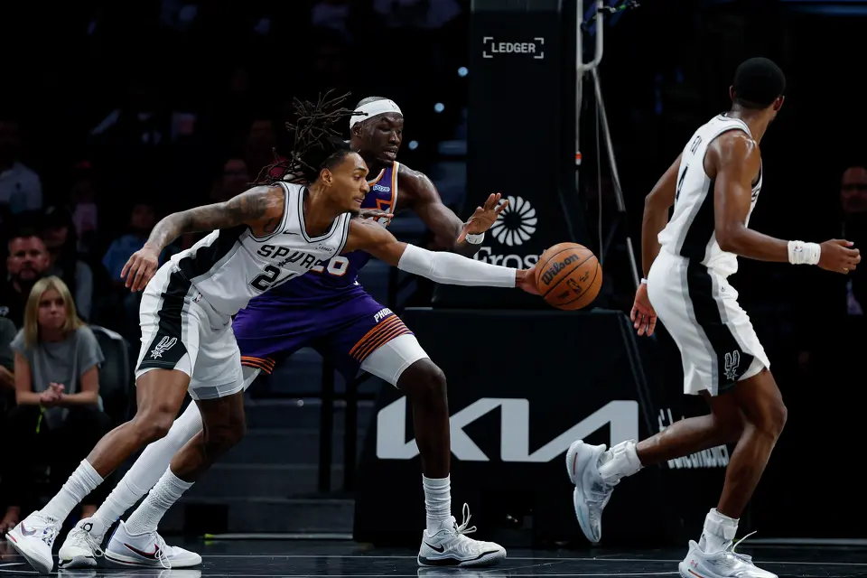 San Antonio Spurs guard Devin Vassell (24) forces a turnover as he swats the ball away from Phoenix Suns center Duop Reath (26) during the first half of a preseason NBA game at Frost Bank Center in San Antonio, Wednesday, Oct. 14, 2026.