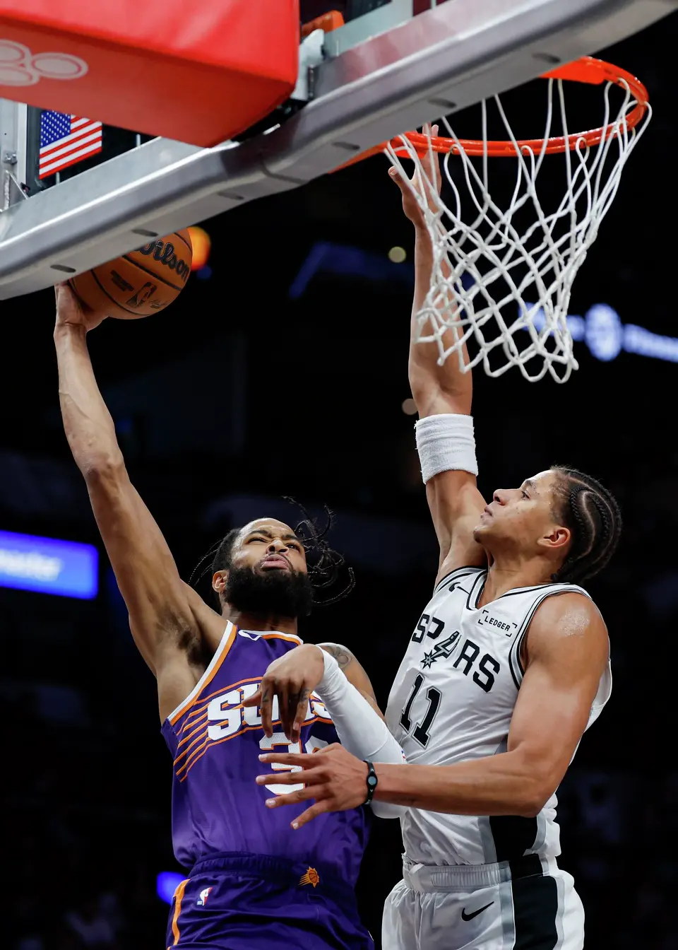 San Antonio Spurs forward Carter Bryant (11) goes up to block Phoenix Suns forward Phillip Wheeler (36) during the second half of a preseason NBA game at Frost Bank Center in San Antonio, Wednesday, Oct. 14, 2026. The Spurs defeated the Suns 123-103.