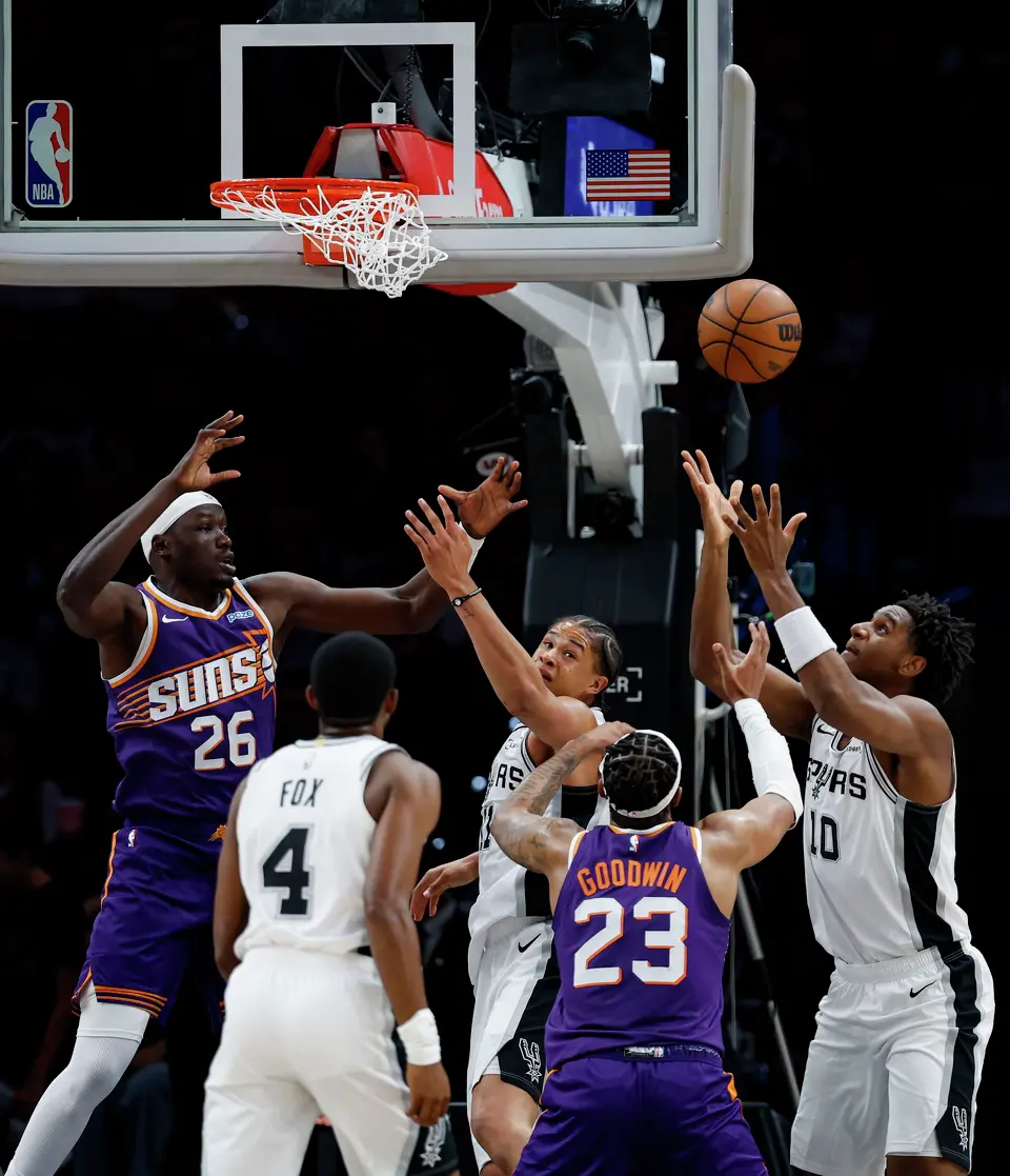 Phoenix Suns center Duop Reath (26), San Antonio Spurs forward Carter Bryant (11), Phoenix Suns guard Jordan Goodwin (23) and San Antonio Spurs center Tarris Reed Jr. (10) go up for a rebound during the first half of a preseason NBA game at Frost Bank Center in San Antonio, Wednesday, Oct. 14, 2026.