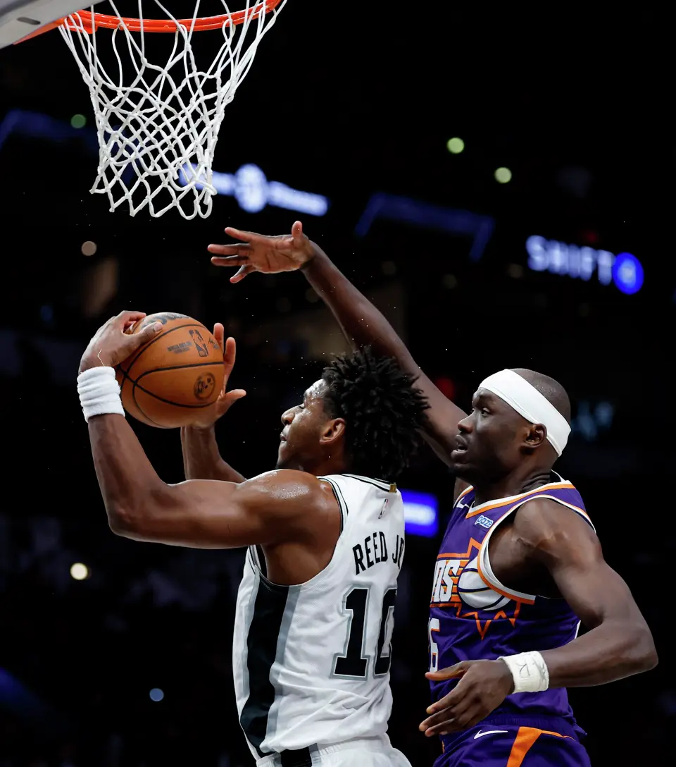 San Antonio Spurs center Tarris Reed Jr. (10) pulls down the rebound over Phoenix Suns center Duop Reath (26) during the second half of a preseason NBA game at Frost Bank Center in San Antonio, Wednesday, Oct. 14, 2026. The Spurs defeated the Suns 123-103.