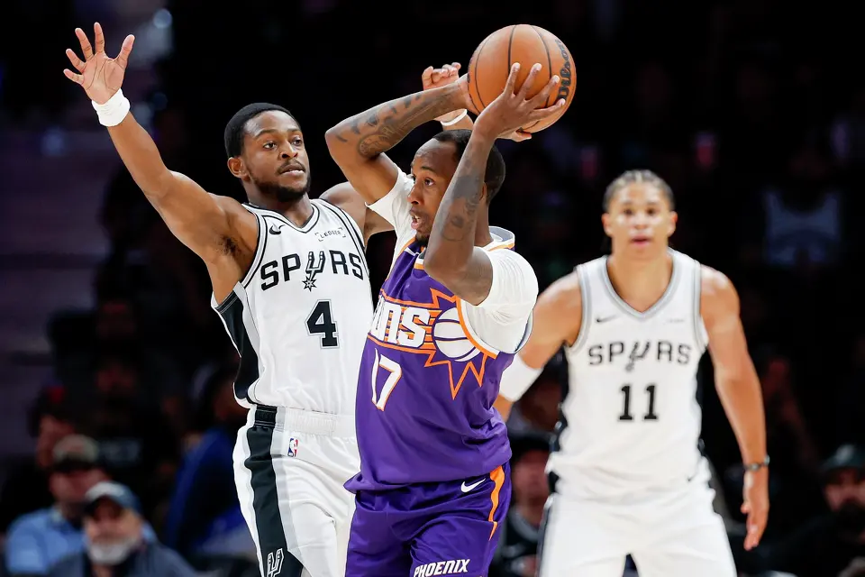 San Antonio Spurs guard De'aaron Fox (4) guards Phoenix Suns guard Jamaree Bouyea (17) during the first half of a preseason NBA game at Frost Bank Center in San Antonio, Wednesday, Oct. 14, 2026.