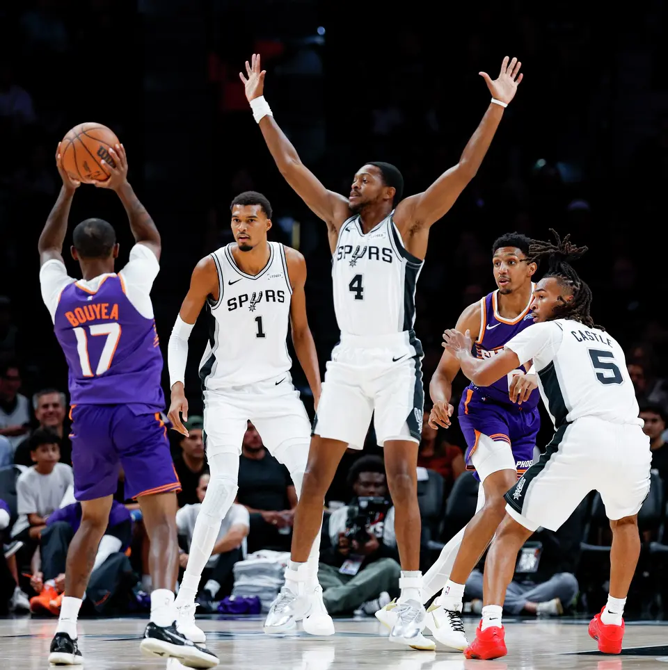 San Antonio Spurs center Victor Wembanyama (1) and guards De'aaron Fox (4) and Stephon Castle (5) play defense against the Phoenix Suns during the first half of a preseason NBA game at Frost Bank Center in San Antonio, Wednesday, Oct. 14, 2026.