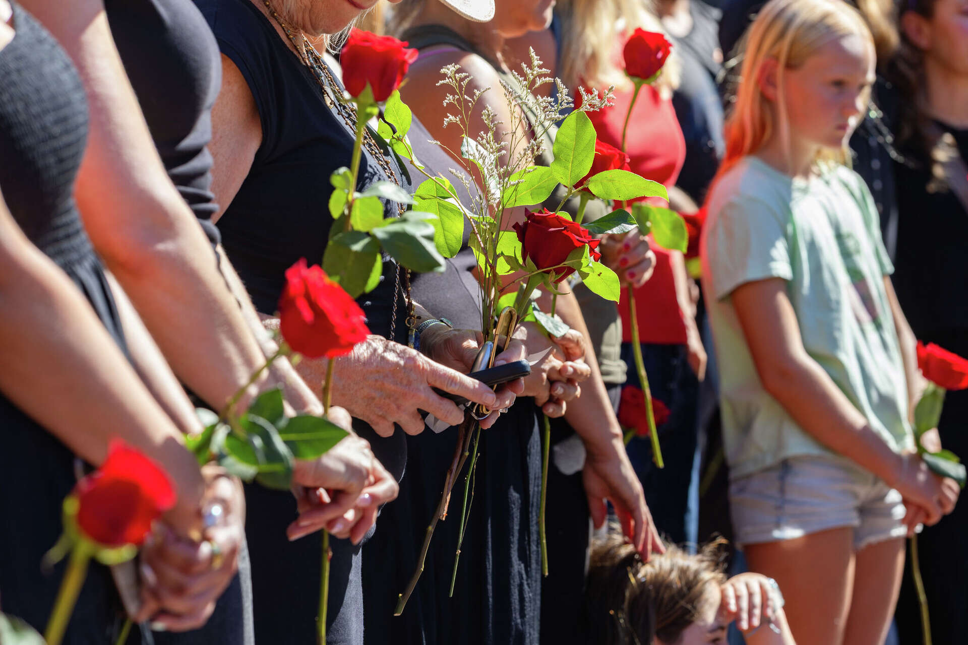 Community members memorialize victims of gun violence Saturday during “The Silent Stand,” vigil at the Mill Valley Depot. The vigil was held in the aftermath of