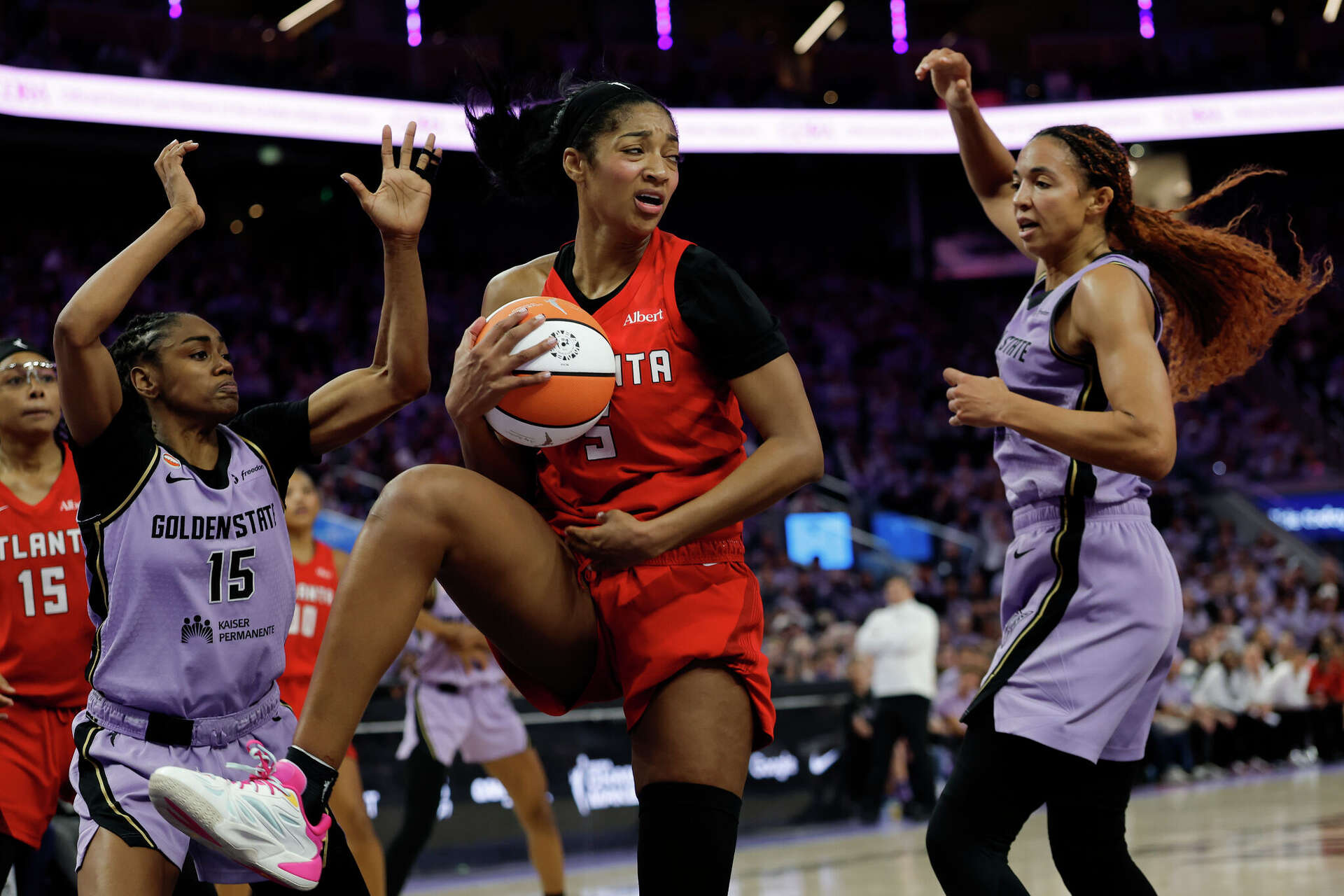 Atlanta Dream forward Angel Reese corrals a rebound between Golden State Valkyries guard Tiffany Hayes (15) and center Kiah Stokes on Monday. Reese finished wit