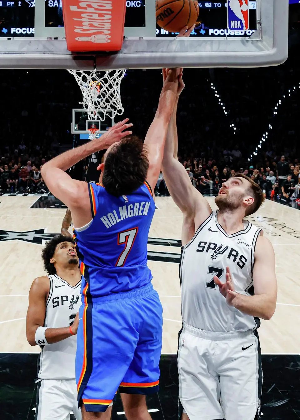 San Antonio Spurs center Luke Kornet (7) fouls Oklahoma City Thunder center Chet Holmgren (7) as Holmgren shoots during the second half of an NBA basketball game Tuesday, Oct. 20, 2026, in San Antonio. The Thunder won 116-104.