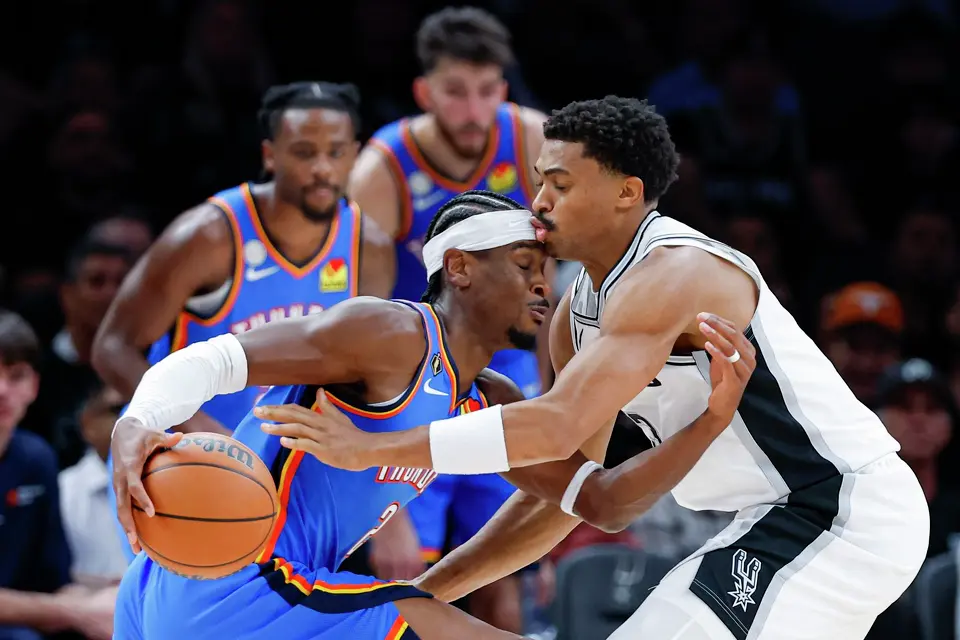 San Antonio Spurs forward Keldon Johnson (3) fouls Oklahoma City Thunder guard Shai Gilgeous-Alexander (2) during the second half of the NBA season opener at Frost Bank Center in San Antonio, Tuesday, Oct. 20, 2026. The Spurs fell to the Thunder 116-104.