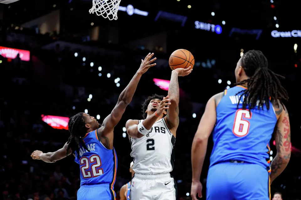 San Antonio Spurs guard Dylan Harper (2) goes up for a shot over Oklahoma City Thunder guard Cason Wallace (22) during the second half of the NBA season opener at Frost Bank Center in San Antonio, Tuesday, Oct. 20, 2026. The Spurs fell to the Thunder 116-104.