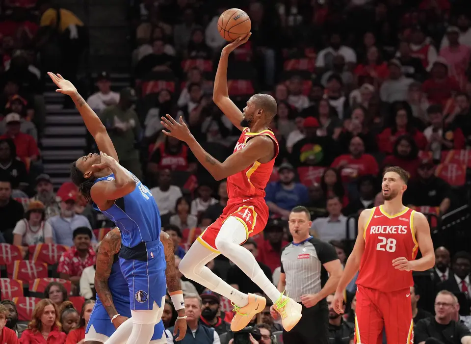 Houston Rockets forward Kevin Durant, center, shoots the ball over Dallas Mavericks forward Morez Johnson Jr., left, during the first half of an NBA basketball game, Wednesday, Oct. 21, 2026, in Houston.